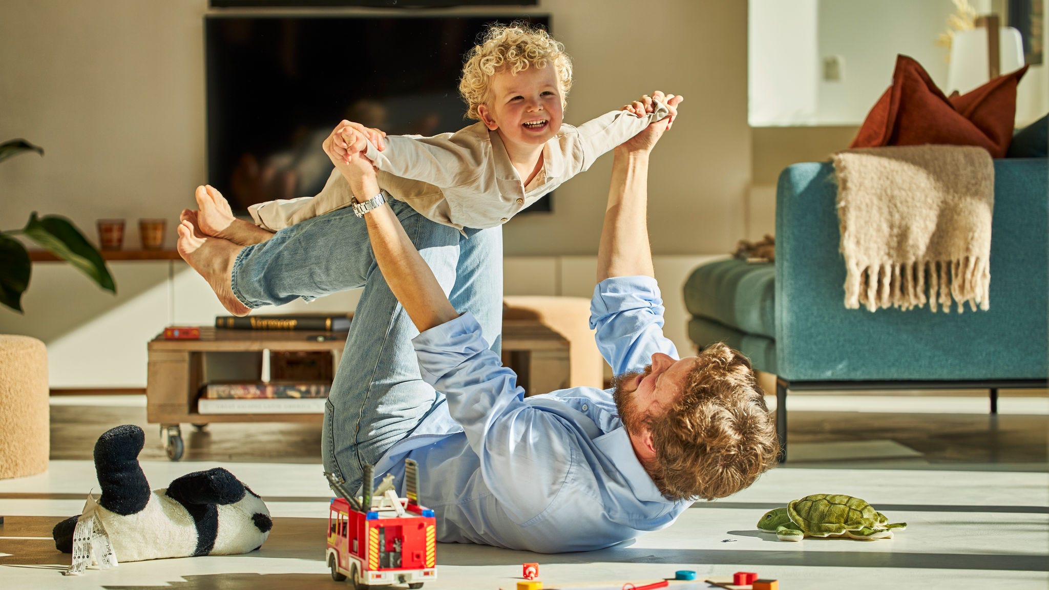 Otac i dijete radosno se igraju i uživaju u toplini podnog grijanja