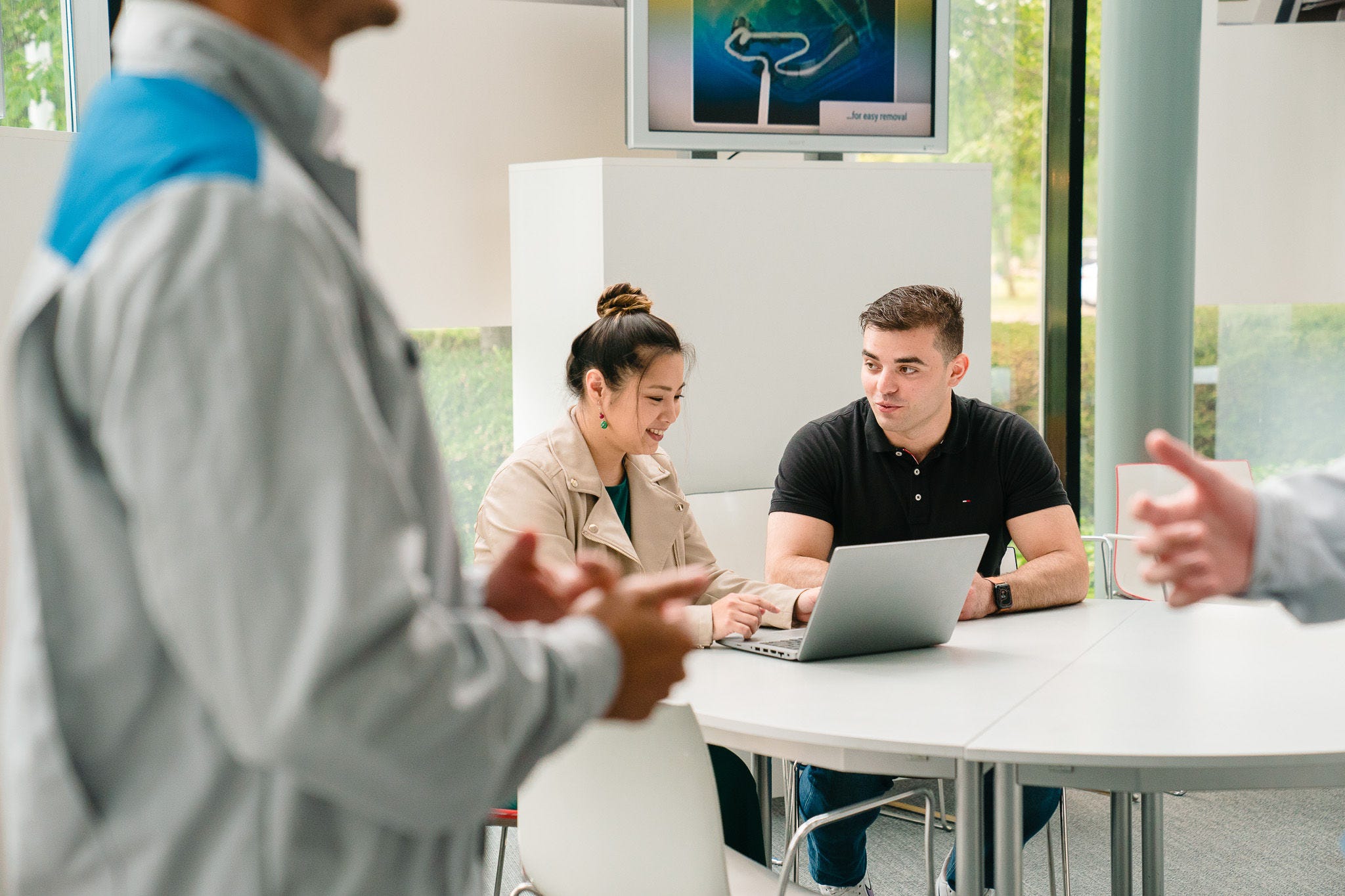 Žena koja muškarcu objašnjava nešto na laptopu