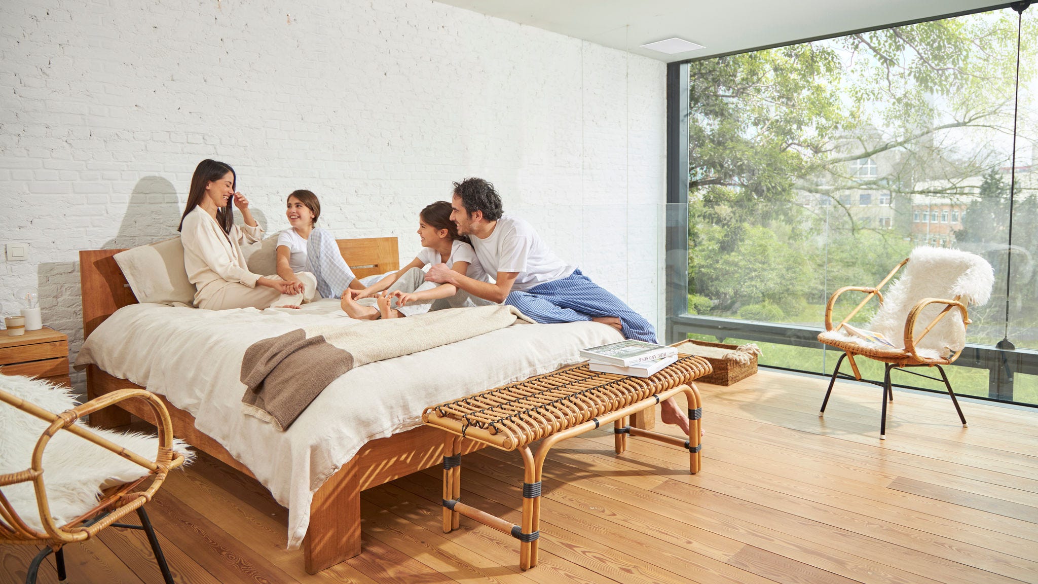 Četveročlana obitelj koja uživa u dobro ventiliranoj spavaćoj sobi