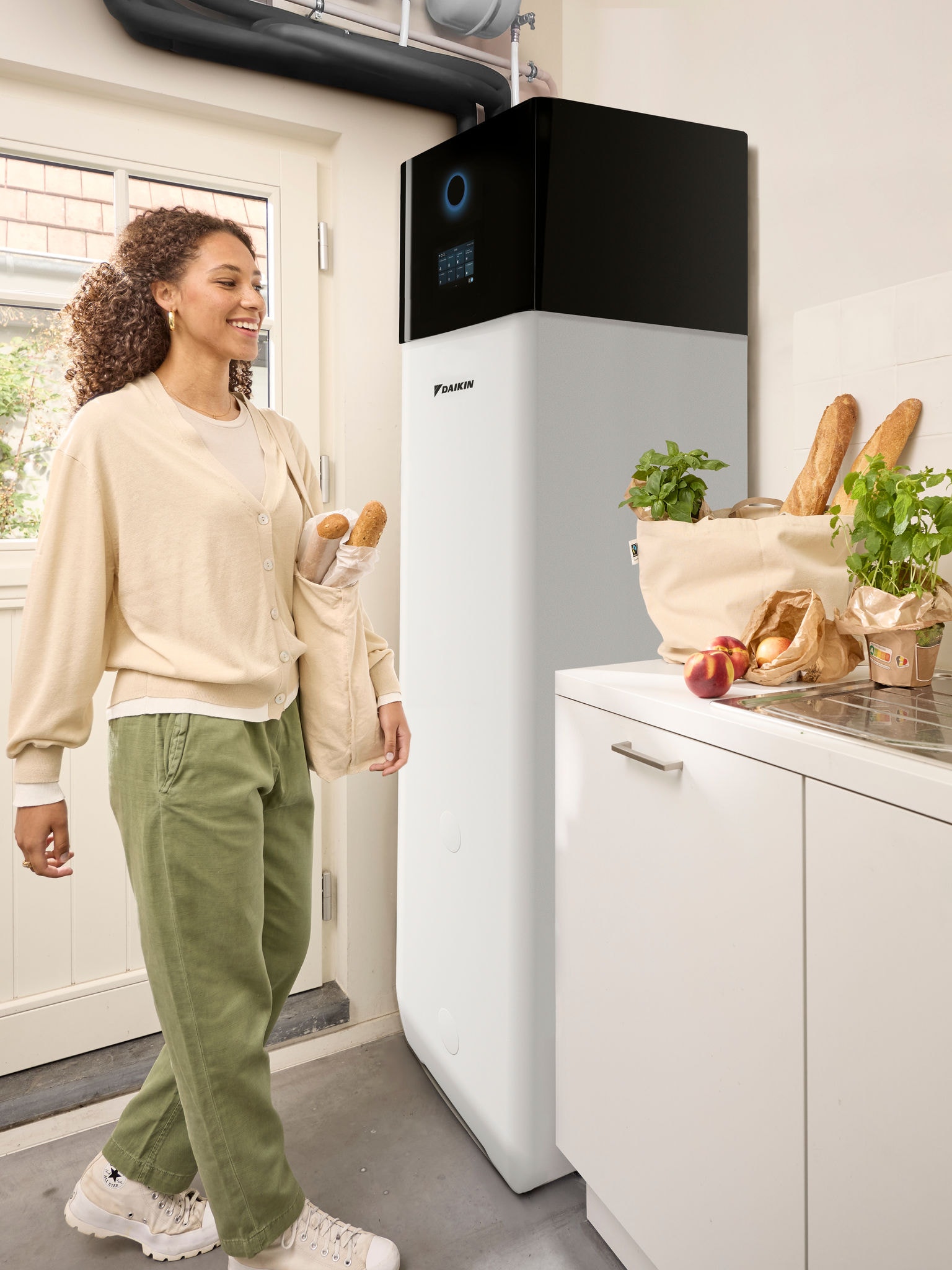 Žena se vraća kući iz kupovine i nosi vrećice iz trgovine