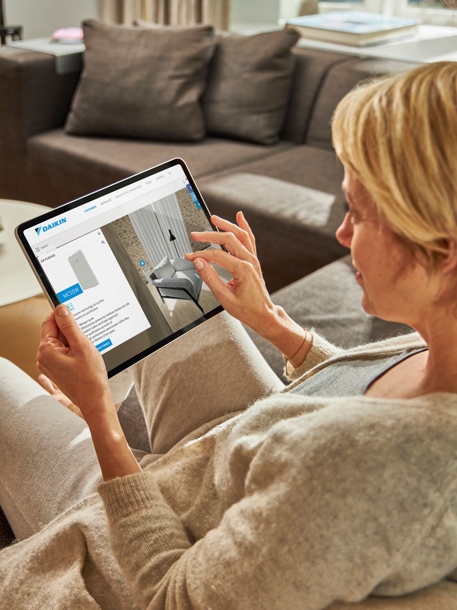 Osoba koja posjećuje virtualni experience centar za pregled pročistača zraka na tablet uređaju