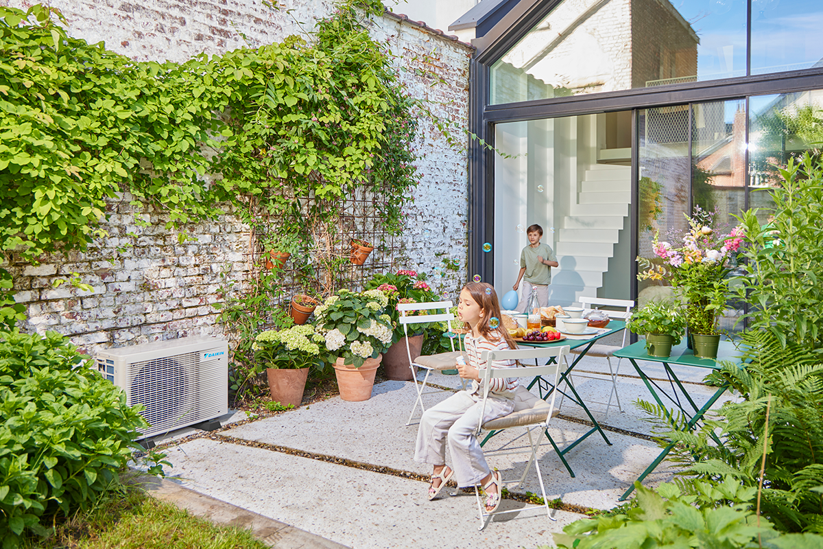Djeca se igraju pikulama na vrtnoj terasi pokraj vanjske jedinice dizalice topline