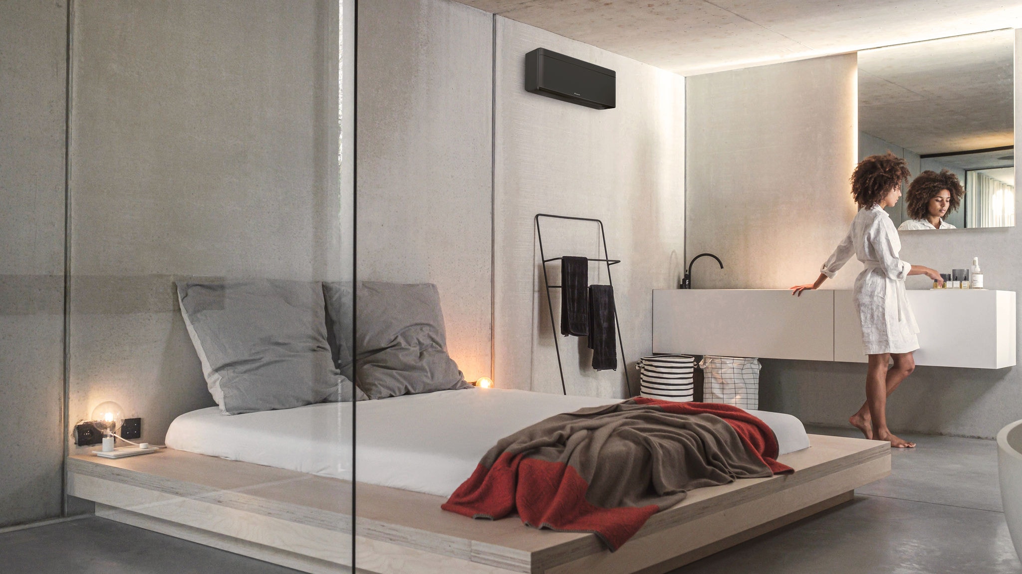 Žena u svojoj spavaćoj sobi s elegantnim Daikin klima-uređajem