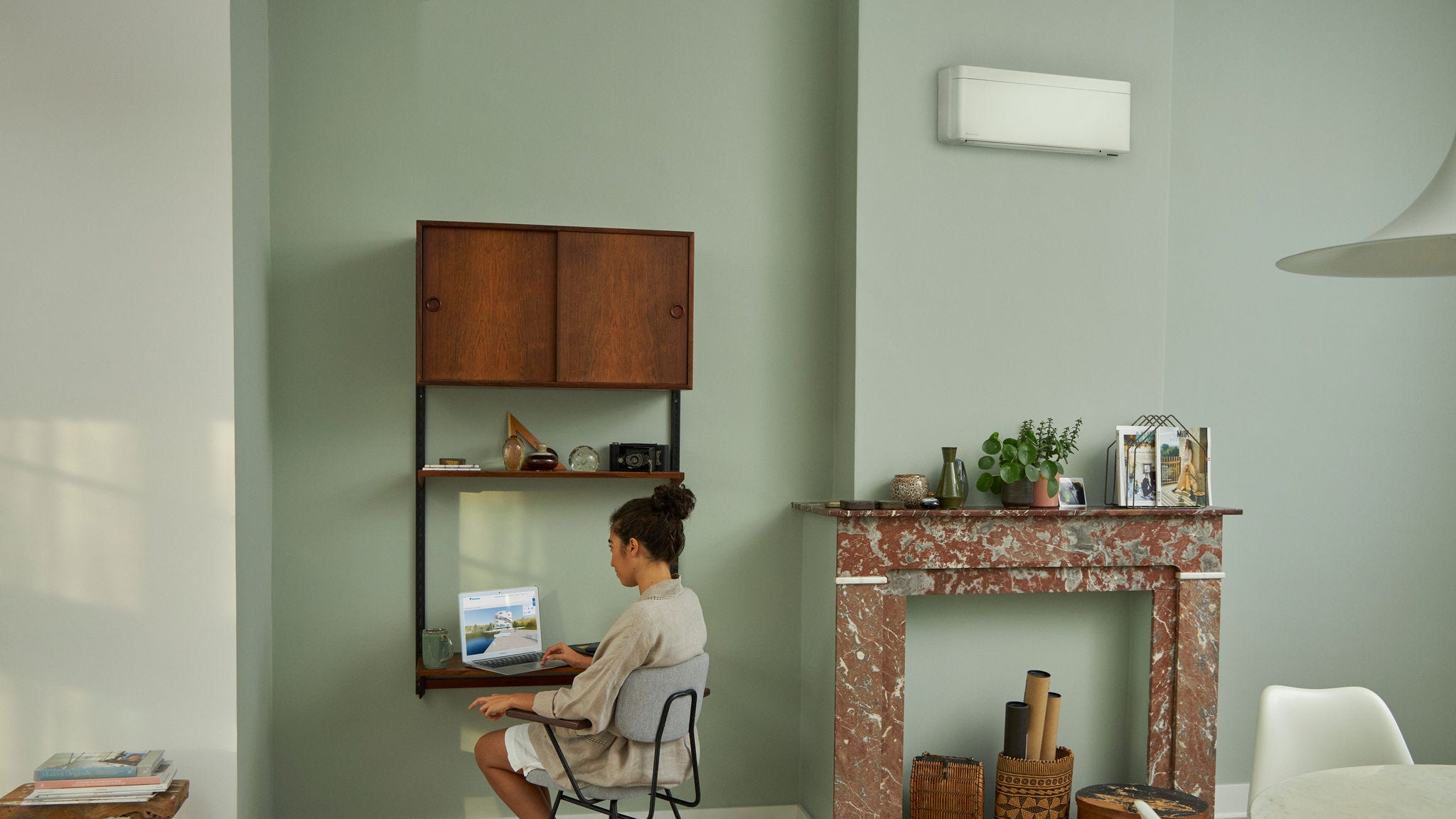 Žena posjećuje Daikin Virtual Experience Center pomoću svog prijenosnog računala u lijepo uređenoj dnevnoj sobi